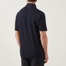 Model wearing Zegna navy polo shirt, rear view, short sleeves, linen cashmere silk blend, paired with dark trousers