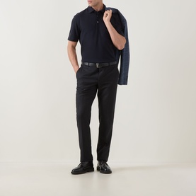 Model wearing Zegna navy linen cashmere silk polo shirt, styled with black trousers, belt, loafers and a navy blazer over one shoulder.