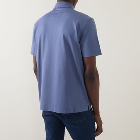 Model wearing Zegna Stitch Logo Polo Shirt in lilac, rear view, short sleeves, straight hem with split side seams, styled with blue jeans.