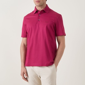 Model wearing Zegna dark pink cotton polo shirt with short sleeves and three-button placket, styled with cream trousers.