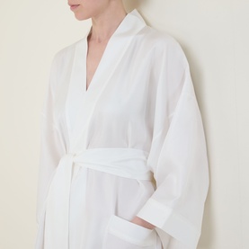 Model wearing Olivia von Halle Tie-Fastening Silk Robe in Ivory Core, with shawl collar, wide sleeves, and self-fabric tie belt.