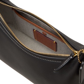 Coach black leather shoulder bag interior view showing grey lining, brown leather patch pocket and gold zip fastening