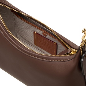 Coach maple leather shoulder bag interior view, showing zip pocket, card slot, and gold-tone zip hardware