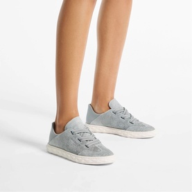 Model wearing Jimmy Choo Diamond Light Flex Trainers in dove mix denim suede, lace-up style with cream rubber sole and collapsible back