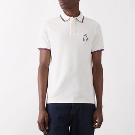 Model wearing Barbour Lure Logo Polo Shirt in Whisper White with burgundy tipped collar and cuffs, lure embroidery chest detail, styled with navy