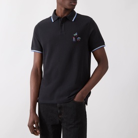 Model wearing Barbour Lure Logo Polo Shirt in Dark Navy with blue tipped collar and cuffs, lure embroidery chest detail, styled with black jeans.