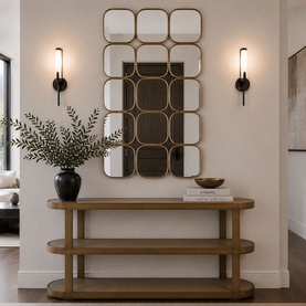 Mindy Browne Nyla Multi-Panel Mirror in gold, rectangular grid design with rounded panels, styled above a wooden console table with wall sconces.