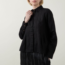 Model wearing InWear Dilana Pleated Linen Shirt in black, with point collar and concealed button placket, styled with striped trousers.