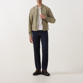 Model wearing Belstaff Carrier Water-Repellent Bomber Jacket in green, styled with white tee, navy trousers and dark brown shoes.