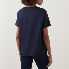 Model wearing Gant Shield Logo T-Shirt in navy, rear view, short sleeves, straight hemline, paired with dark jeans