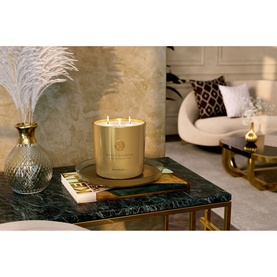 Rituals Sweet Jasmine Scented Candle in gold vessel with three wicks, styled on marble table in luxury living room setting