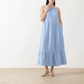Model wearing Part Two Light Blue halterneck maxi dress with tiered skirt, styled with gold flat sandals
