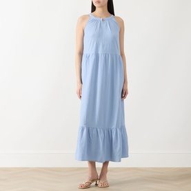Model wearing Part Two Light Blue maxi dress with halterneck tie, tiered skirt and ruffle hem, styled with gold sandals