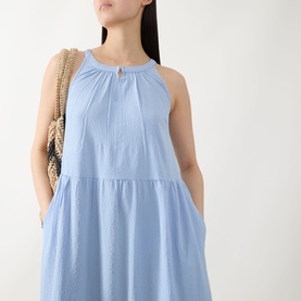 Model wearing Part Two Light Blue halterneck tiered dress with gathered neckline detail, styled with a woven straw bag.