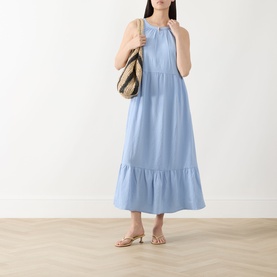 Model wearing Part Two light blue sleeveless midi dress with tiered hem, styled with strappy sandals and woven shoulder bag.