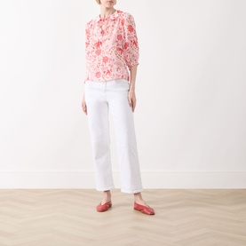 Model wearing Part Two Judyas Cropped Straight Leg Jeans in white, styled with a red floral blouse and red flat shoes.