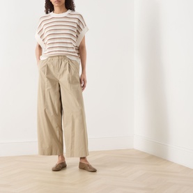 Model wearing Part Two Belisia Striped Sweater in beige with crew neck and short sleeves, styled with wide-leg cropped trousers and flat mules.