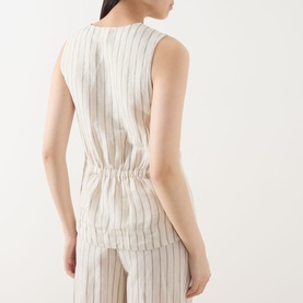 Model wearing Part Two cream striped sleeveless linen-blend top with elasticated waist, styled with matching stripe trousers, back view.
