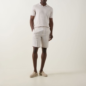 Model wearing Brunello Cucinelli Fine Knit Polo Shirt in Juta with matching linen shorts and beige suede loafers.