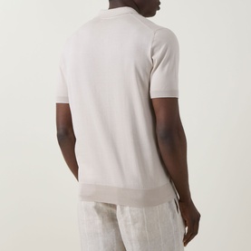 Model wearing B Cucinelli Fine Knit Polo Shirt in Juta, back view, short sleeves with ribbed trims, styled with linen trousers.