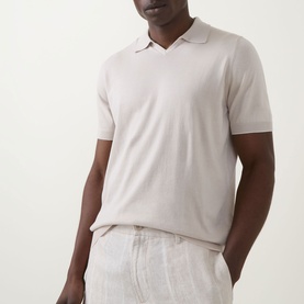 Model wearing B Cucinelli Fine Knit Polo Shirt in Juta, featuring open flat collar, short sleeves and ribbed trims, styled with linen trousers
