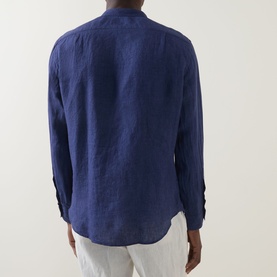 Model wearing Boggi Milano navy blue linen casual shirt, rear view showing relaxed fit and curved hem, styled with white trousers.