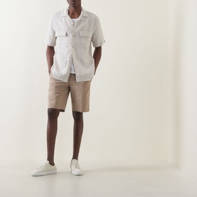 Model wearing Boggi Milano sand linen casual shirt with chest pockets, styled with beige shorts and white trainers.