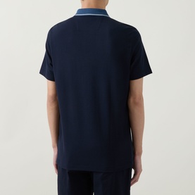 Model wearing Boggi Milano navy blue polo shirt, rear view, with light blue tipped collar and matching navy trousers.