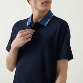 Model wearing Boggi Milano navy blue polo shirt with contrast light blue tipped collar, short sleeves, shown in close-up detail shot.