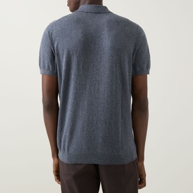 Model wearing Boggi Milano Solid Polo Shirt in indigo, rear view, short-sleeved linen-cotton knit, styled with dark trousers.