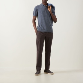 Model wearing Boggi Milano Solid Polo Shirt in indigo, linen-cotton blend, paired with dark brown trousers and grey slip-on shoes.
