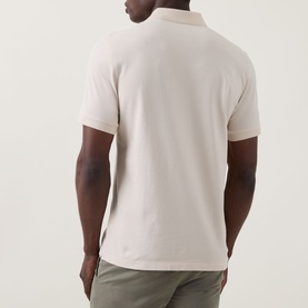 Model wearing Boggi Milano Solid Logo Piqu&eacute; Polo Shirt in Natural. Rear view showing piqu&eacute; texture and polo collar. Styled with khaki trousers.