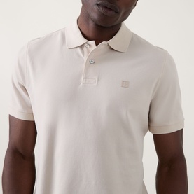 Model wearing Boggi Milano Solid Logo Piqu&eacute; Polo Shirt in Natural, with polo collar, two-button placket and chest logo detail.