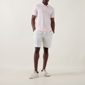 Model wearing Boggi Milano Solid Logo Piqu&eacute; Polo Shirt in pink with white shorts and white trainers.