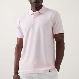 Model wearing Boggi Milano Solid Logo Piqu&eacute; Polo Shirt in pink, with two-button placket, short sleeves, and embroidered chest logo, styled with light
