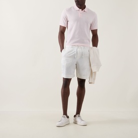 Model wearing Boggi Milano Solid Logo Piqu&eacute; Polo Shirt in pink, styled with white shorts and white trainers, carrying a cream jacket.