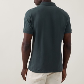 Model wearing Boggi Milano Solid Logo Piqu&eacute; Polo Shirt in green, rear view, short sleeves, styled with cream trousers.