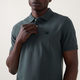 Model wearing Boggi Milano Solid Logo Piqu&eacute; Polo Shirt in green, showing chest logo detail, polo collar and two-button placket.