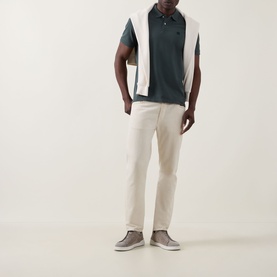 Model wearing Boggi Milano Solid Logo Piqu&eacute; Polo Shirt in green with white contrast panels, styled with cream trousers and grey suede shoes.