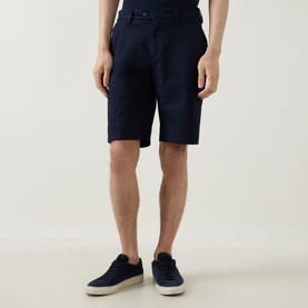 Model wearing Boggi Milano navy blue cotton shorts with belt loops, styled with white trainers and a light top.