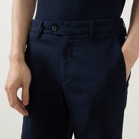 Model wearing Boggi Milano navy blue cotton-elastane trousers, close-up of waistband and front pocket detail.
