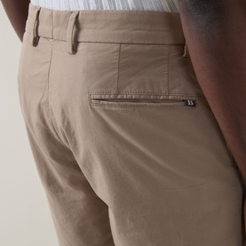 Model wearing Boggi Milano Slim-Leg Bermuda Shorts in Mud, close-up of rear jetted pocket with logo detail and belt loops visible.