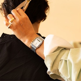 Model with Casio AQ-230A-7AMQYES silver stainless steel watch with rectangular white dial on silver bracelet strap