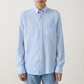 Model wearing Gant Reg Shirt in sky blue linen-cotton blend, button-down collar, chest pocket, paired with blue jeans