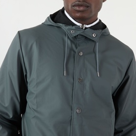 Model wearing Rains Casual Jacket in Dark Grey, showing hooded neckline with drawstring and snap button fastening detail.
