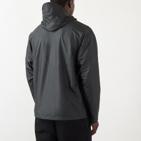 Model wearing Rains black casual jacket, rear view, hooded with clean seam detailing, styled with black trousers
