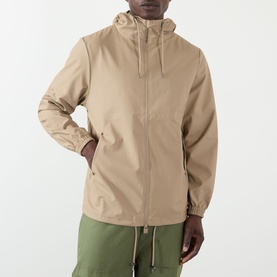 Model wearing Rains Casual Jacket in beige with hood and zip fastening, styled with olive green trousers.
