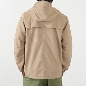 Model wearing Rains Casual Jacket in beige, rear view showing hooded design and clean back seam, styled with green trousers