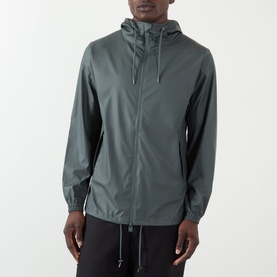 Model wearing Rains Dark Grey casual jacket with hood, zip fastening and dropped hem, styled with black trousers