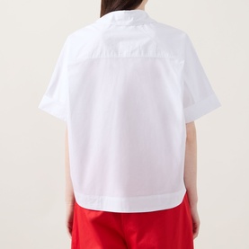 Model wearing InWear Ellin Solid Blouse in white, back view, showing short sleeves, curved hem and crisp cotton finish, styled with red trousers.
